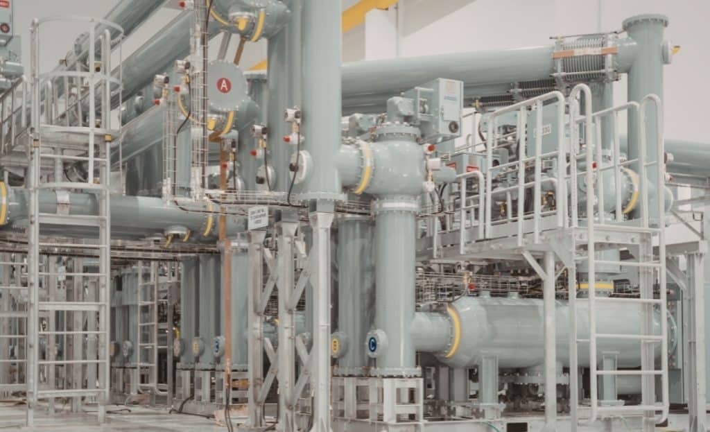 Large industrial pipes and valves at a power plant process facility